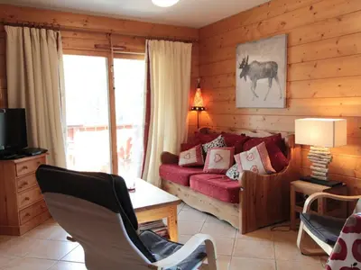 a living room with a red couch and a table at Appartement 3 Pièces 6 Pers avec Balcon aux Carroz - FR-1-572-53 in Les Carroz d'Araches