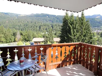 a balcony with a table and chairs and mountains at Appartement 3 Pièces 6 Pers avec Balcon aux Carroz - FR-1-572-53 in Les Carroz d'Araches