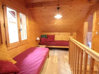 a small room with a bed in a wooden cabin at Chalet équipé avec poêle et garage, proche centre et remontées mécaniques - FR-1-572-107 in Les Carroz d'Araches