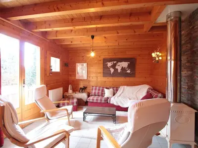 a room with a couch and chairs in a cabin at Chalet équipé avec poêle et garage, proche centre et remontées mécaniques - FR-1-572-107 in Les Carroz d'Araches