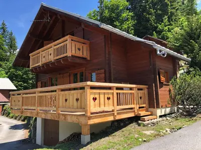 a large wooden house with a large deck at Chalet équipé avec poêle et garage, proche centre et remontées mécaniques - FR-1-572-107 in Les Carroz d'Araches