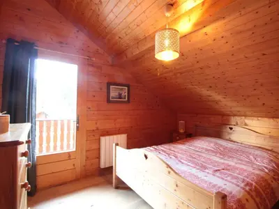 a bedroom with a bed in a wooden cabin at Chalet équipé avec poêle et garage, proche centre et remontées mécaniques - FR-1-572-107 in Les Carroz d'Araches
