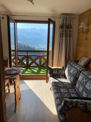 a living room with a couch and a large window at Studio magnifique saint Gervais les bains in Saint-Gervais-les-Bains