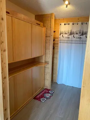 a room with wooden cabinets and a shower curtain at Studio magnifique saint Gervais les bains in Saint-Gervais-les-Bains