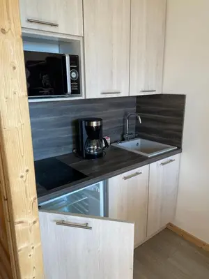 a kitchen with a sink and a microwave at Studio magnifique saint Gervais les bains in Saint-Gervais-les-Bains
