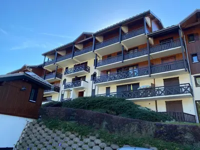 a building with balconies on top of a hill at Studio magnifique saint Gervais les bains in Saint-Gervais-les-Bains