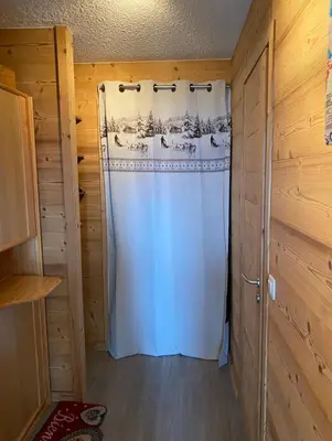 a shower in a room with a white shower curtain at Studio magnifique saint Gervais les bains in Saint-Gervais-les-Bains