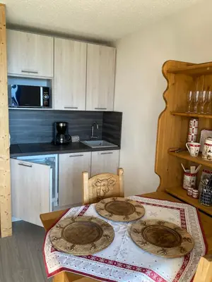 a kitchen with a table with two plates on it at Studio magnifique saint Gervais les bains in Saint-Gervais-les-Bains