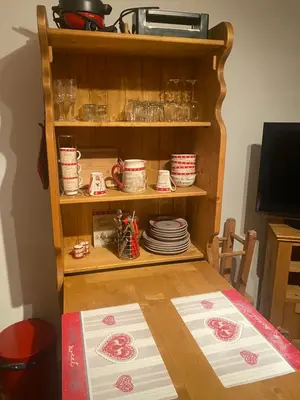 a table with plates and dishes on a shelf at Studio magnifique saint Gervais les bains in Saint-Gervais-les-Bains