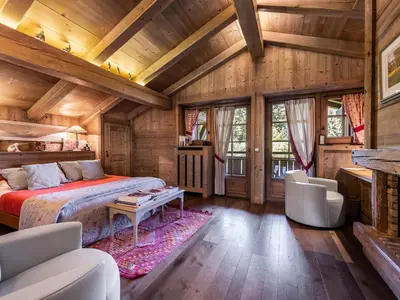 a bedroom in a log cabin with a bed and chairs at Chalet familial à Megève avec piscine et sauna pour 12 personnes - FR-1-569-2 in Megève