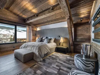 a bedroom with a bed in a room with wooden walls at Chalet de luxe avec jacuzzi, salle cinéma et piscine au centre de Megève - FR-1-569-10 in Megève