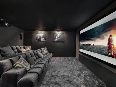 a living room with a large tv and a couch at Chalet de luxe avec jacuzzi, salle cinéma et piscine au centre de Megève - FR-1-569-10 in Megève