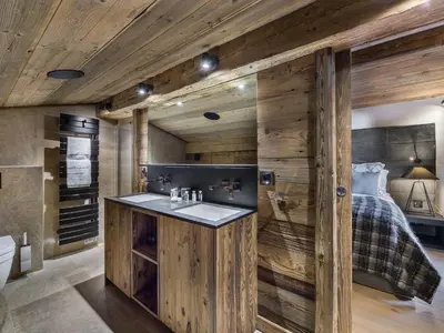 a bathroom with wooden walls and a sink and a bed at Chalet de luxe avec jacuzzi, salle cinéma et piscine au centre de Megève - FR-1-569-10 in Megève