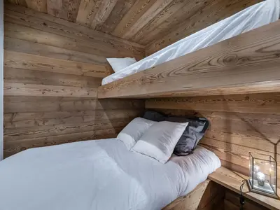 a bed in a log cabin with two bunk beds at Charmant appartement au Mont d'Arbois proche pistes, parking inclus - FR-1-569-11 in Megève