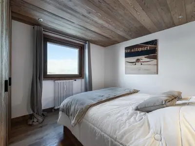a bedroom with a large bed and a window at Charmant appartement au Mont d'Arbois proche pistes, parking inclus - FR-1-569-11 in Megève