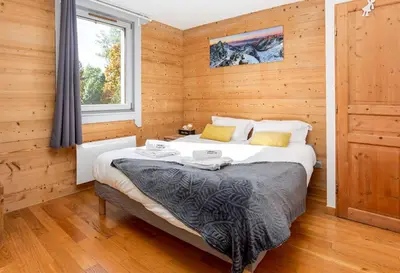 a bedroom with a bed in a wooden room at Le Paradis 25 Apartment - Chamonix All Year in Chamonix-Mont-Blanc