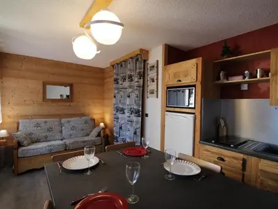 a kitchen and living room with a table and a couch at Studio rénové cosy, 4 pers, au pied des pistes, balcon ouest, proche commerces, parking inclus - FR-1-572-66 in Les Carroz d'Araches
