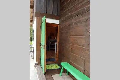 a green bench sitting in the entrance to a room at Petit chalet savoyard in Domancy