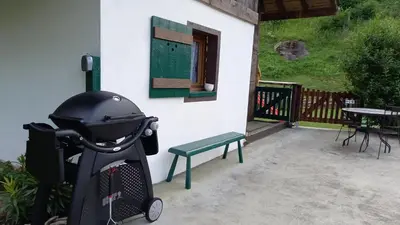 a stroller parked next to a building with a bench at Petit chalet savoyard in Domancy