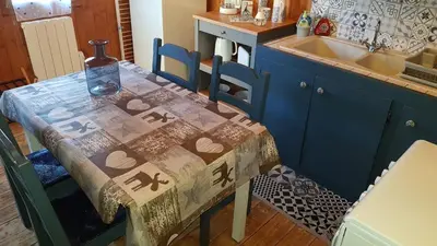 a kitchen with a table with a bottle on it at Petit chalet savoyard in Domancy