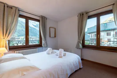 a bedroom with a white bed and two windows at DIFY René Payot - Chamonix-Mont-Blanc in Chamonix-Mont-Blanc