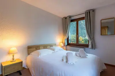 a bedroom with a large white bed and a window at DIFY René Payot - Chamonix-Mont-Blanc in Chamonix-Mont-Blanc