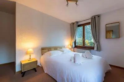 a bedroom with a large white bed and a window at DIFY René Payot - Chamonix-Mont-Blanc in Chamonix-Mont-Blanc