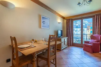 a dining room with a table and a balcony at DIFY Paccard - Chamonix-Mont-Blanc in Chamonix-Mont-Blanc