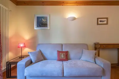 a blue couch with a pillow on it in a living room at DIFY Paccard - Chamonix-Mont-Blanc in Chamonix-Mont-Blanc