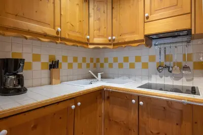 a kitchen with wooden cabinets and a sink at DIFY Paccard - Chamonix-Mont-Blanc in Chamonix-Mont-Blanc