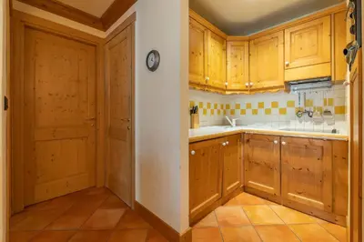 a kitchen with wooden cabinets and a clock on the wall at DIFY Paccard - Chamonix-Mont-Blanc in Chamonix-Mont-Blanc