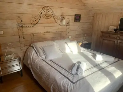 a bedroom with a white bed with a wooden wall at Le Solli in Saint-Gervais-les-Bains