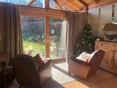 a living room with two chairs and a christmas tree at Le Solli in Saint-Gervais-les-Bains