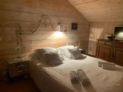 a bedroom with a bed with two pairs of slippers on it at Le Solli in Saint-Gervais-les-Bains