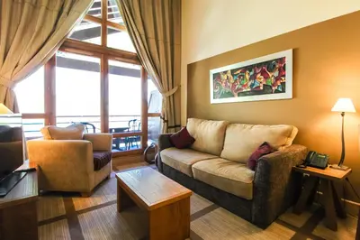 a living room with a couch and a chair at Les Terrasses d'Eos, 1-bed apartment with fireplace, Ski in, Ski out in Flaine