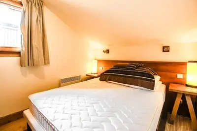 a bedroom with a large white bed and a window at Les Terrasses d'Eos, 1-bed apartment with fireplace, Ski in, Ski out in Flaine