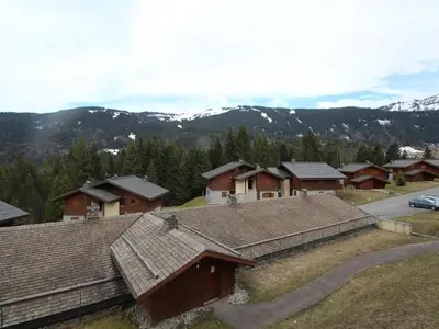 a group of houses with mountains in the background at Chalet 4 pièces + mezzanine, 8 pers, WiFi, parking, proche spa, arrêt ski-bus - FR-1-572-112 in Les Carroz d'Araches