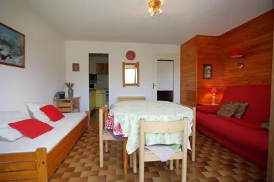 a bedroom with two beds and a red couch at PE255 Studio 4 pers pieds de piste in Les Carroz d'Araches