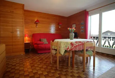 a dining room with a table and a red chair at PE255 Studio 4 pers pieds de piste in Les Carroz d'Araches