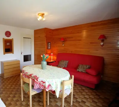 a living room with a red couch and a table at PE255 Studio 4 pers pieds de piste in Les Carroz d'Araches