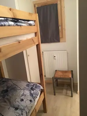 a room with two bunk beds and a stool at VAR50 - Studio 4 Pers centre des Carroz in Les Carroz d'Araches