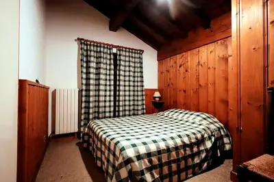 a bedroom with a bed with a checkered blanket at Chalet Ulysse - Chalet Ulysse MAE-6403 in Les Houches