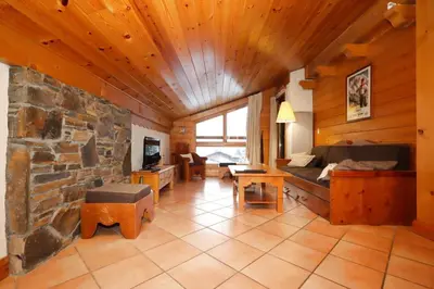 a living room with a couch and a stone fireplace at Résidence Les Hauts De Chavants - Hauts de Chavants Albert 1er 13 MAE-6404 in Les Houches