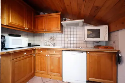 a kitchen with wooden cabinets and white appliances at Résidence Les Hauts De Chavants - Hauts de Chavants Albert 1er 13 MAE-6404 in Les Houches