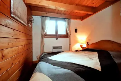 a bedroom with a large bed with a window at Résidence Les Hauts De Chavants - Hauts de Chavants Albert 1er 13 MAE-6404 in Les Houches