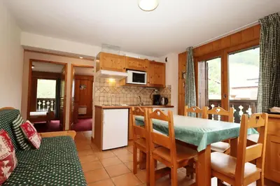 a kitchen and dining room with a table and chairs at Résidence Le Saint Georges - Saint-Georges 07 MAE-6405 in Les Houches