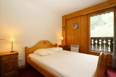 a bedroom with a white bed and a window at Résidence Le Saint Georges - Saint-Georges 07 MAE-6405 in Les Houches