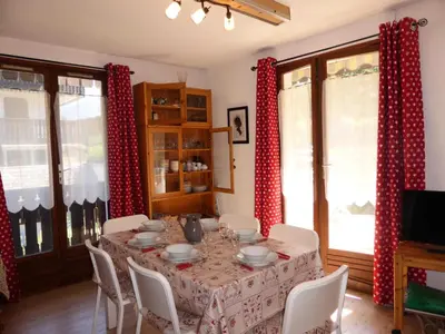 a dining room table with red and white drapes at Résidence Aiguille Du Midi Bat A - Aiguille du Midi A778 MAE-6406 in Les Houches