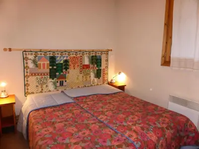 a bedroom with a bed with a colorful bedspread at Résidence Les Amethystes B - Améthystes B02 MAE-6409 in Les Houches