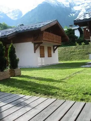 a house with a grass yard and a wooden deck at Résidence Les Amethystes B - Améthystes B02 MAE-6409 in Les Houches